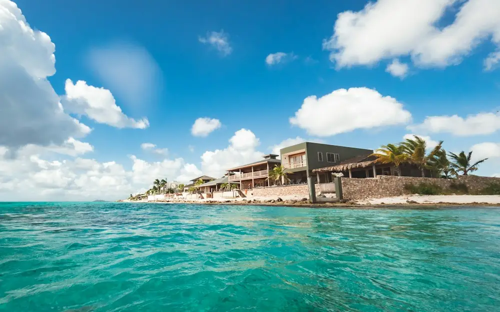 a house sitting on top of a sandy beach next to the ocean