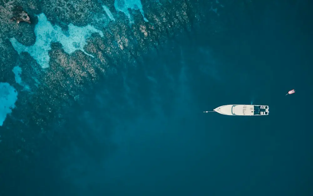an aerial view of a boat in the ocean